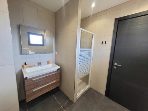 une salle de bain avec un lavabo et un miroir dans l'établissement Studio Port de Porto-Vecchio, à Porto-Vecchio