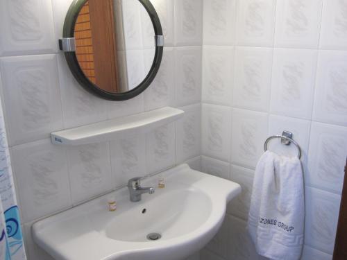 a white bathroom with a sink and a mirror at Amazones Villas Apartments in Stalís