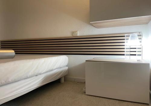 une chambre avec deux lits, une table et une fenêtre dans l'établissement Côté Plages, à Sète