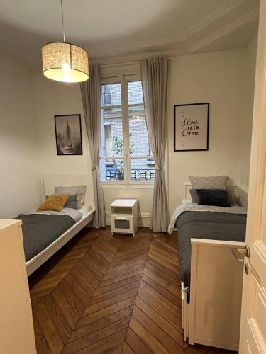 une chambre avec deux lits et une fenêtre dans l'établissement Appartement au cœur de Paris, à Paris