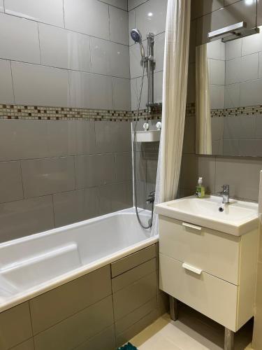 une salle de bain avec une baignoire, un lavabo et une douche dans l'établissement Appartement au cœur de Paris, à Paris