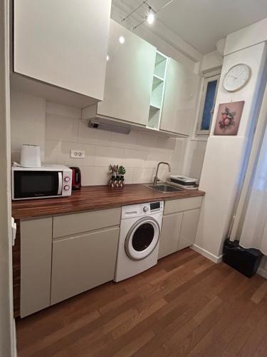 une cuisine avec un lave-linge et un micro-ondes dans l'établissement Appartement au cœur de Paris, à Paris