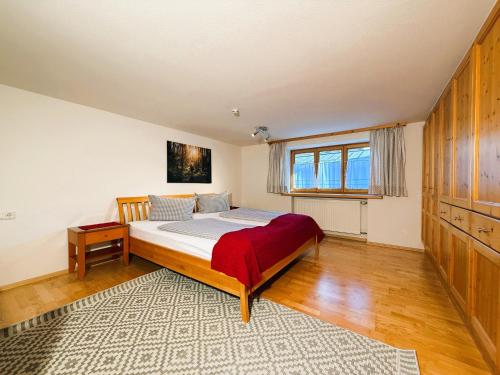 a bedroom with a bed and a table and a window at Ferienwohnung Poldi - Annehmlichkeiten von 4-Sterne Familien- und Wellnesshotel Viktoria können mitgenutzt werden in Oberstdorf