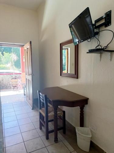 a dining room with a table and a tv on the wall at Hotel Quinta Loreto in San Miguel de Allende