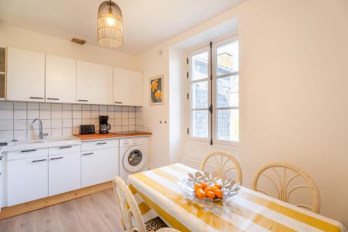 une cuisine et une salle à manger avec une table et des chaises dans l'établissement Le Maurice - Vannes centre 4 pers bohème chic, à Vannes