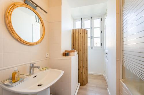 une salle de bain avec un lavabo et un miroir dans l'établissement Le Maurice - Vannes centre 4 pers bohème chic, à Vannes