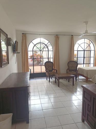 a living room with two windows and a table and chairs at Hotel Quinta Loreto in San Miguel de Allende