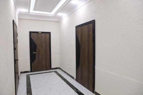 a hallway with two doors and a tile floor at Lavender Haven in Khujand