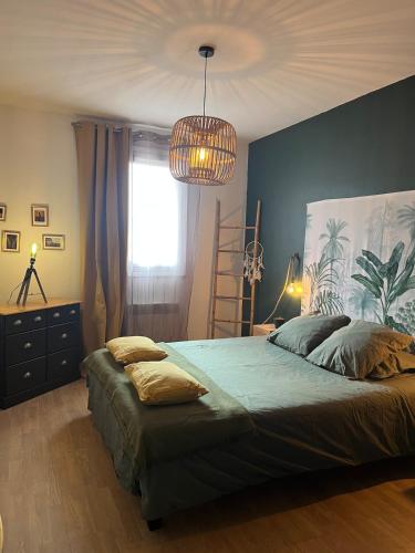 une chambre avec un grand lit et un lustre dans l'établissement Appartement T3 centre ville Propriano, à Propriano