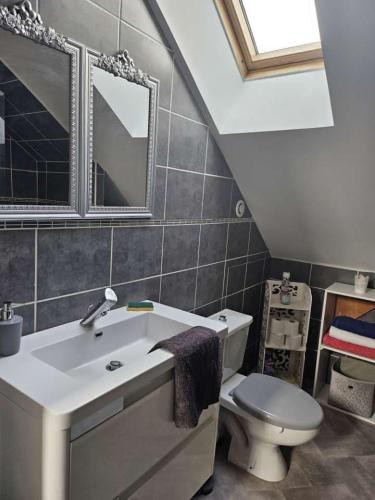 une salle de bain avec un lavabo blanc et des toilettes dans l'établissement Jolie maison de ville, à Montluçon