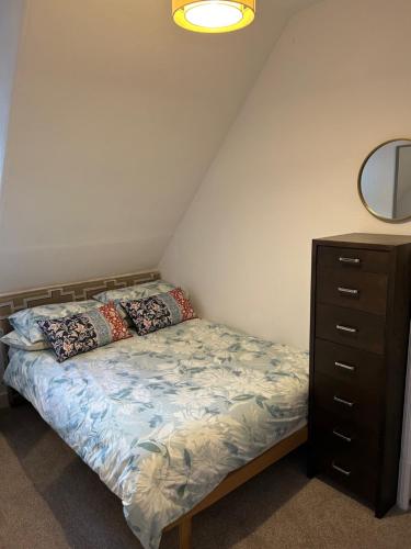 a bedroom with a bed with a dresser and a mirror at Eilean View in Lamlash