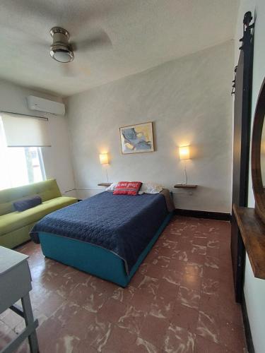 a bedroom with a blue bed and a couch at DGM Lofts MTY MN 960 E centro cerca de todo in Monterrey