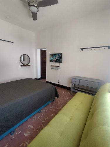 a bedroom with a bed and a couch and a tv at DGM Lofts MTY MN 960 E centro cerca de todo in Monterrey