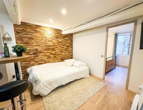 a bed in a room with a brick wall at Charming Flat in the Historic Center of Saint-Rémy in Saint-Rémy-de-Provence