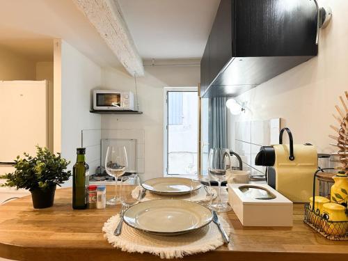 - une cuisine avec une table en bois et des verres à vin dans l'établissement Charming Flat in the Historic Center of Saint-Rémy, à Saint-Rémy-de-Provence