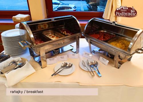 a table with two trays of food on it at Hotel Podhradie in Považská Bystrica