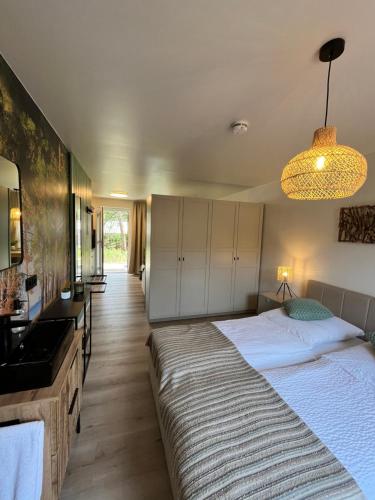 a bedroom with a large bed and a sink at Bungalow Green Forest in Benz