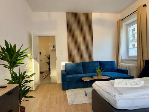 a living room with a blue couch and a table at Modernes Apartment 6 Personen Zentral 65qm WLAN gehobene Ausstattung in Hannover