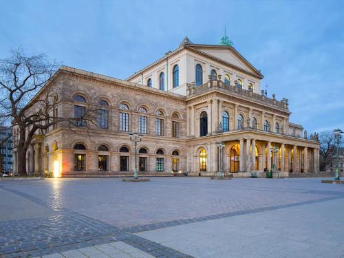 a large stone building with a courtyard in front of it at Modernes Apartment 6 Personen Zentral 65qm WLAN gehobene Ausstattung in Hannover
