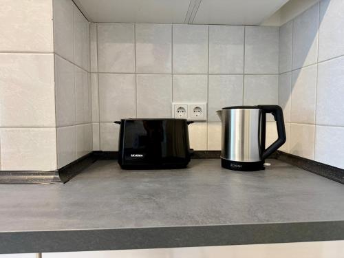 a microwave and a coffee pot sitting on a counter at Modernes Apartment 6 Personen Zentral 65qm WLAN gehobene Ausstattung in Hannover