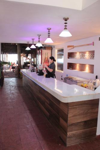 a woman standing at a bar in a restaurant at Bungalows Garza Blanca a Pie de Playa in San Blas