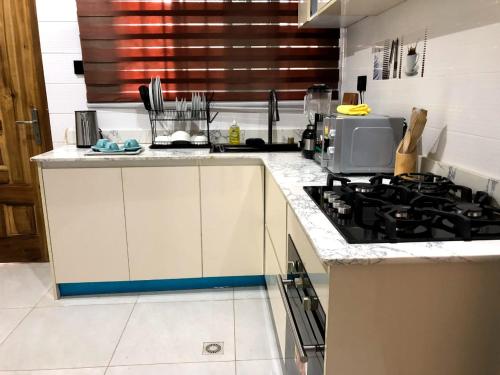 a kitchen with a stove and a counter top at Norichyank Apartments in Amasaman