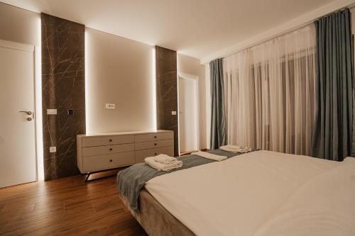 a bedroom with a bed and a dresser and a mirror at Darki Comfort Apartments - Stylish and Comfortable Apartments with Free Parking in Ohrid