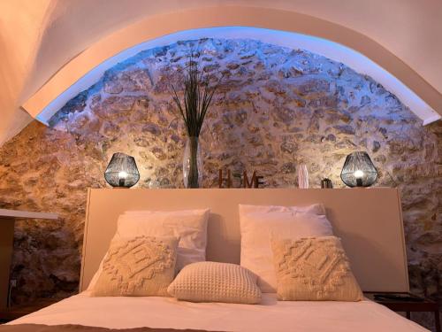 - une chambre dotée d'un grand mur et d'un lit avec deux lampes dans l'établissement Studio de Charme au Suquet, à Cannes