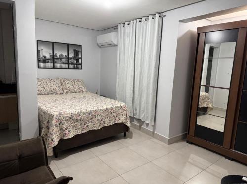 een kleine slaapkamer met een bed en een spiegel bij Apartamento Setor Universitário in Goiânia