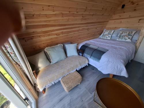 a bedroom with a bed and a chair in a cabin at Beautiful and Cosy Garden Pod Saintives in Carbis Bay