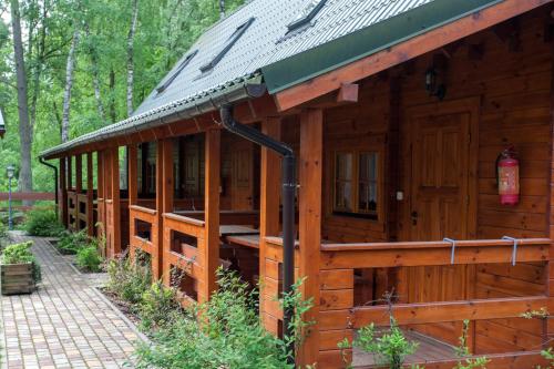 a large wooden cabin with a metal roof at Angela Domki i Pokoje in Pobierowo