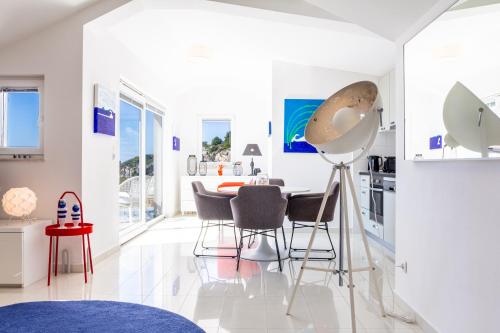 a white kitchen with a table and chairs in a room at Blue Bay Residence in Hvar