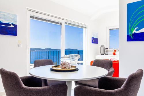 a dining room with a white table and chairs at Blue Bay Residence in Hvar