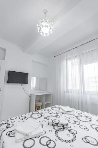 a bedroom with a bed with a black and white blanket at Sea vibes-Mamaia Nord in Năvodari