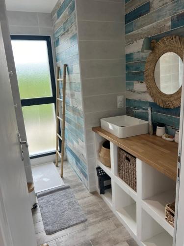 une salle de bain avec un lavabo et un miroir dans l'établissement Maison entre océan et forêt landaise, à Vielle-Saint-Girons