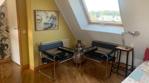 - deux chaises et une table dans une chambre avec fenêtre dans l'établissement Chambres d'hôtes Villa Symphorien Surzur, à Surzur