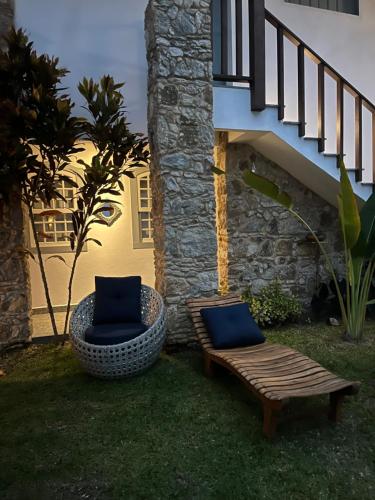 two chairs and a bench next to a building at Casa Arte Cabore in Paraty