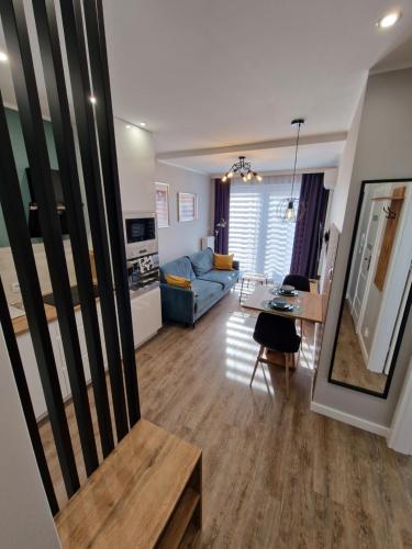 Una sala de estar con un sofá azul y una mesa. en Apartament Busko Odnova, en Busko-Zdrój