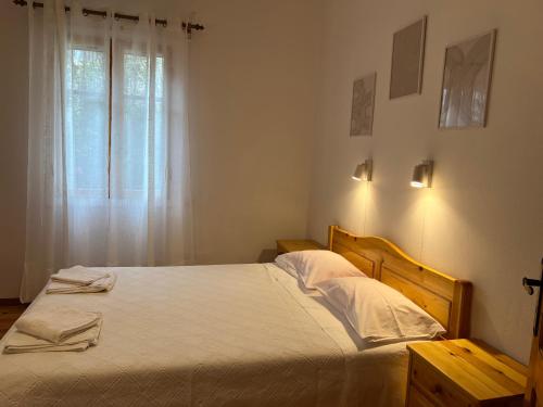 a bedroom with a bed with white sheets and a window at ERIDA Accommodation in Lákka