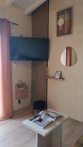 a room with a table with a magazine on it at La mini villa Ondella à Porticcio in Grosseto-Prugna