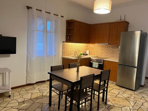 a kitchen with a table and a stainless steel refrigerator at ERIDA Accommodation in Lákka