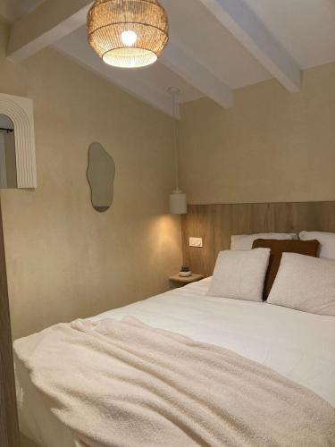 a bedroom with a large white bed and a lamp at La mini villa Ondella à Porticcio in Grosseto-Prugna