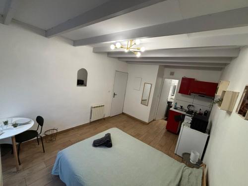 Cette chambre comprend un lit, une table et une cuisine. dans l'établissement Charmant Studio Montpellier hypercentre, à Montpellier