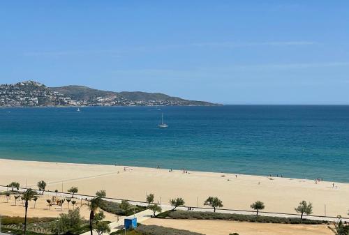 a beach with people on the sand and the ocean at Seafront Apartment with air conditioner in Empuriabrava