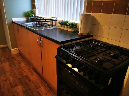 a kitchen with a stove and a counter top at The Park Lane Retreat - Contractors welcome in Middlesbrough