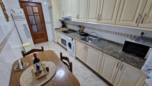 a kitchen with a table and a sink and a stove at Apartamento CORAZÓN DE MIÑO in Miño