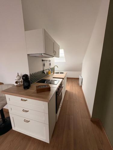 a kitchen with white cabinets and a stove top oven at Le Nid dHistoire avec vue sur la cathédrale in Bayeux