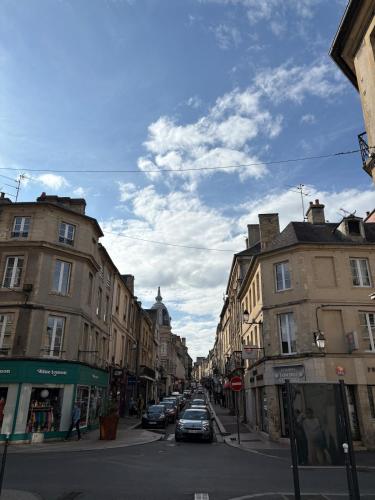 a city street with buildings and cars parked on the street at Le Nid dHistoire avec vue sur la cathédrale in Bayeux