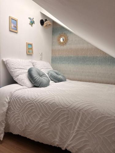a bedroom with a bed with two pillows on it at Le Nid dHistoire avec vue sur la cathédrale in Bayeux