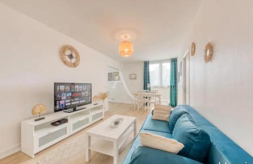a living room with a blue couch and a tv at Urban Paradise near Orly Airport and Paris in Thiais